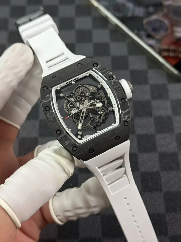 RM 055 white carbon composite case with white rubber strap held in a gloved hand