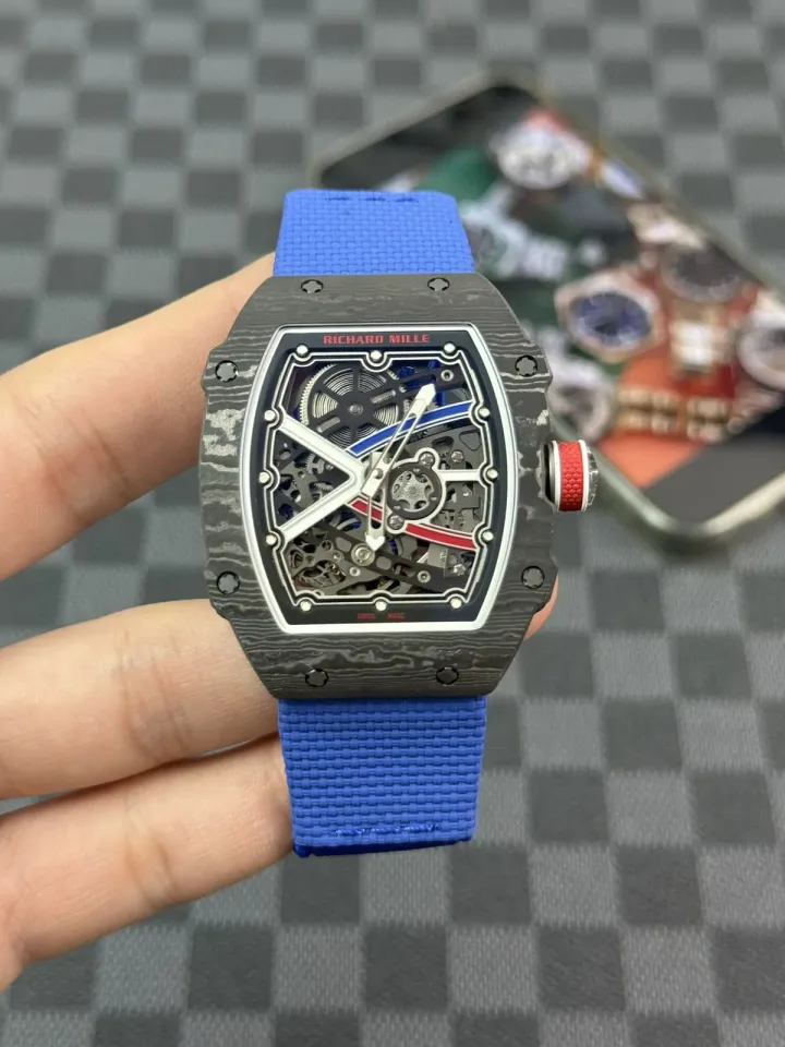 RM 67-02 with blue textile strap and red crown held in a gloved hand